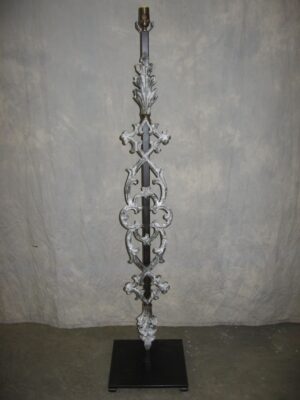 Gothic style custom iron floor lamp with a white, distressed finish and a dark iron base.