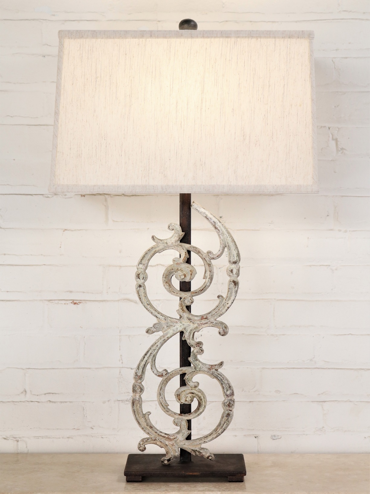 Pontalba custom iron table lamp with a white, distressed finish and a dark iron base. Paired with a 17 inch rectangle linen lamp shade.