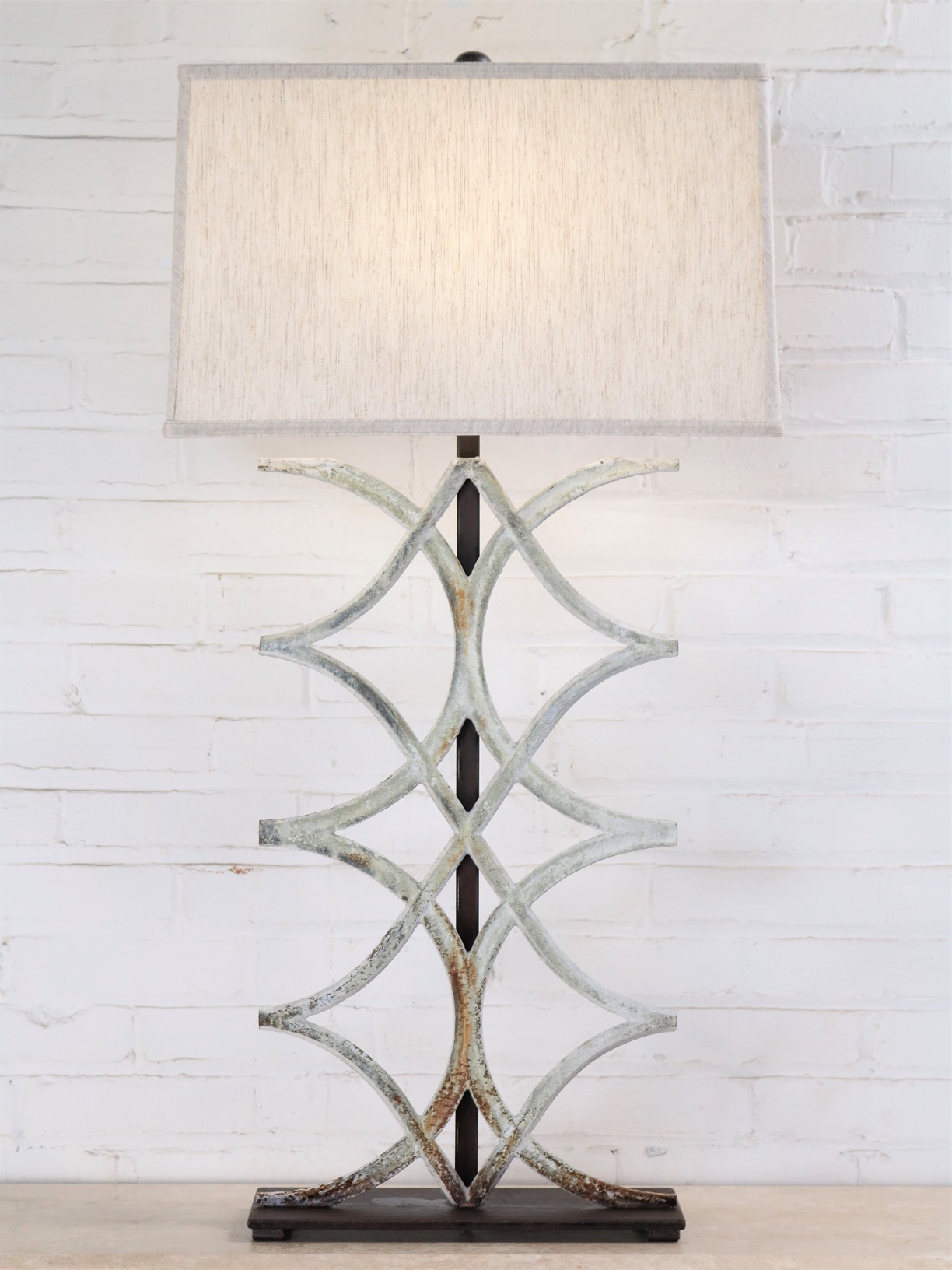 Arcs custom iron table lamp with a white distressed finish and a dark iron base. Paired with a 19 inch rectangle linen lamp shade.