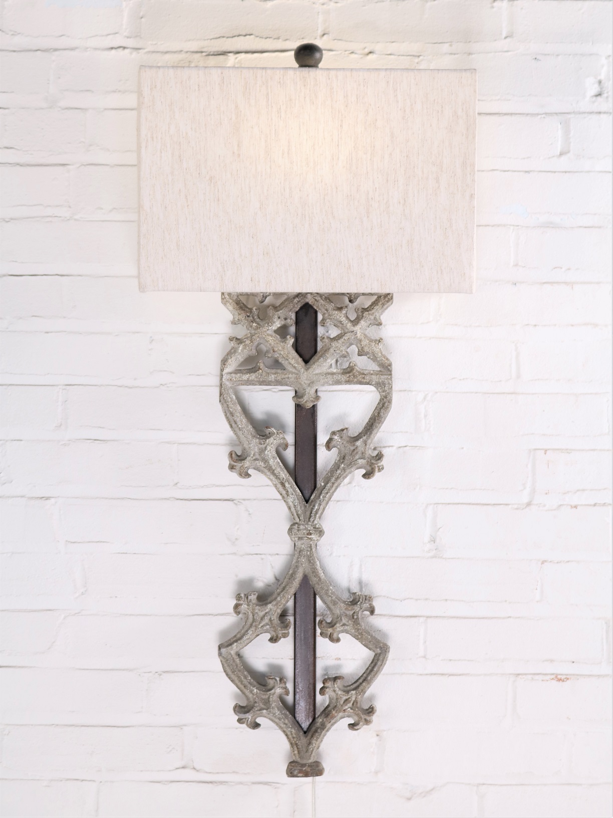 Gothic style custom iron wall sconce with a gray, distressed finish. Paired with a half rectangle linen lamp shade.