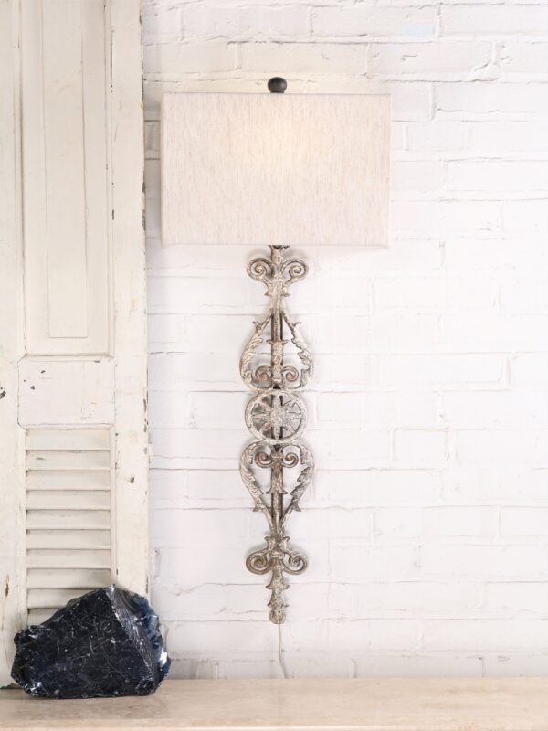 Spanish style custom iron wall sconce with a white, distressed finish. Paired with a half rectangle linen lamp shade